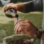 A man pours red wine into a decanter. Photo courtesy of The Good Pour.